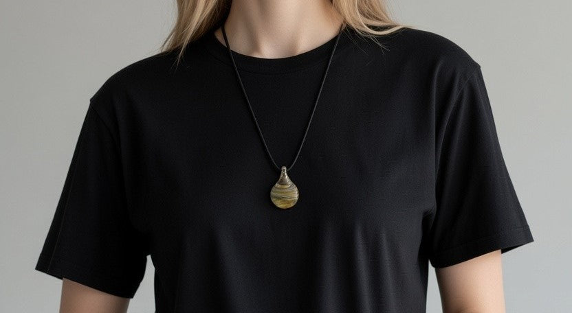 Striped glass teardrop pendant worn over a black T-shirt
