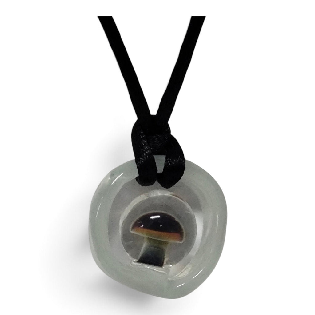 Close-up of the small mushroom sealed inside the clear glass disc