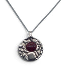 Bronze pendant with a garnet enamel inlay on a silver chain
